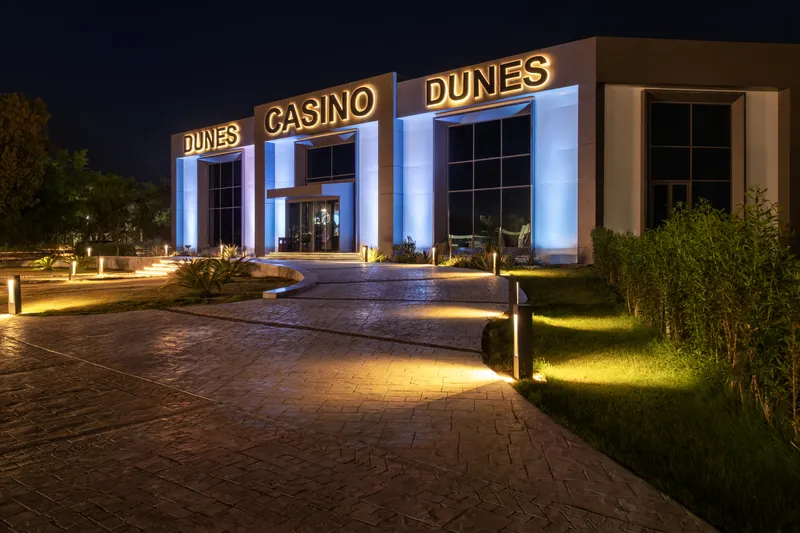 The lit facade of Dunes Casino at night